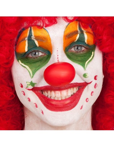 Naso clown rosso morbido indossato su viso con trucco colorato verde e arancione per costume pagliaccio