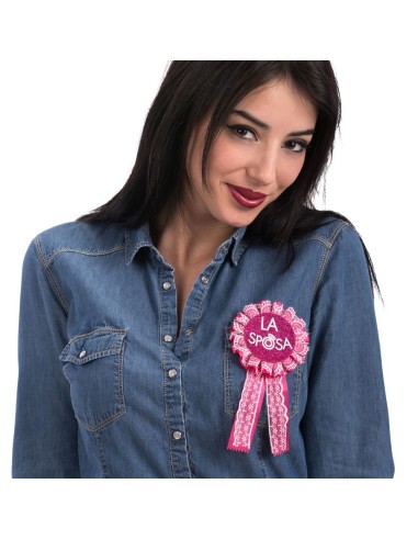 Coccarda rosa LA SPOSA con nastri per addio al nubilato applicata su camicia denim