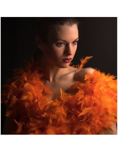 Donna con boa di piume arancione fluo voluminoso per feste e spettacoli