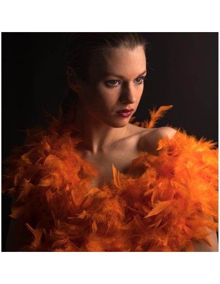 Donna con boa di piume arancione fluo voluminoso per feste e spettacoli
