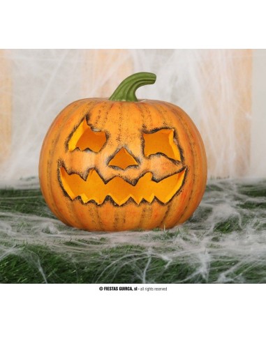Zucca Halloween arancione intagliata in foam 20 cm con faccia spaventosa su ragnatele decorative
