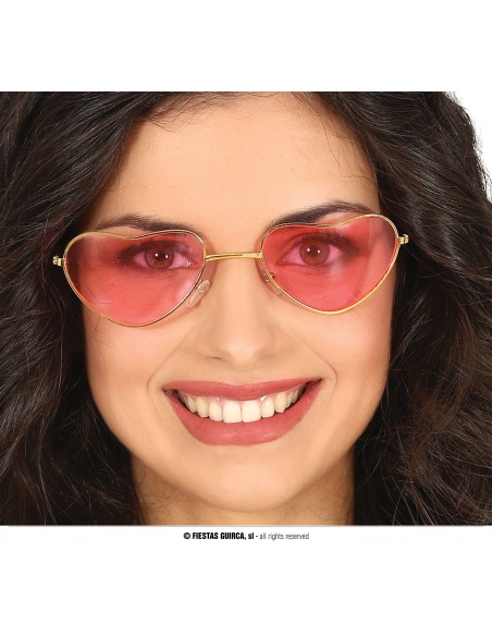 Occhiali a forma di cuore con lenti rosse sfumate e montatura dorata indossati da donna sorridente