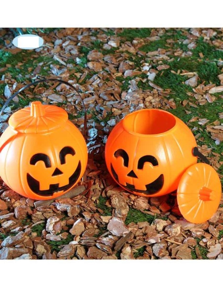 Zucche decorative arancioni Halloween con coperchio e volto intagliato jack-o'-lantern su foglie autunnali